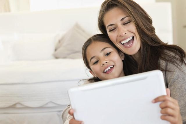 Woman and her daughter looking at a digital tablet